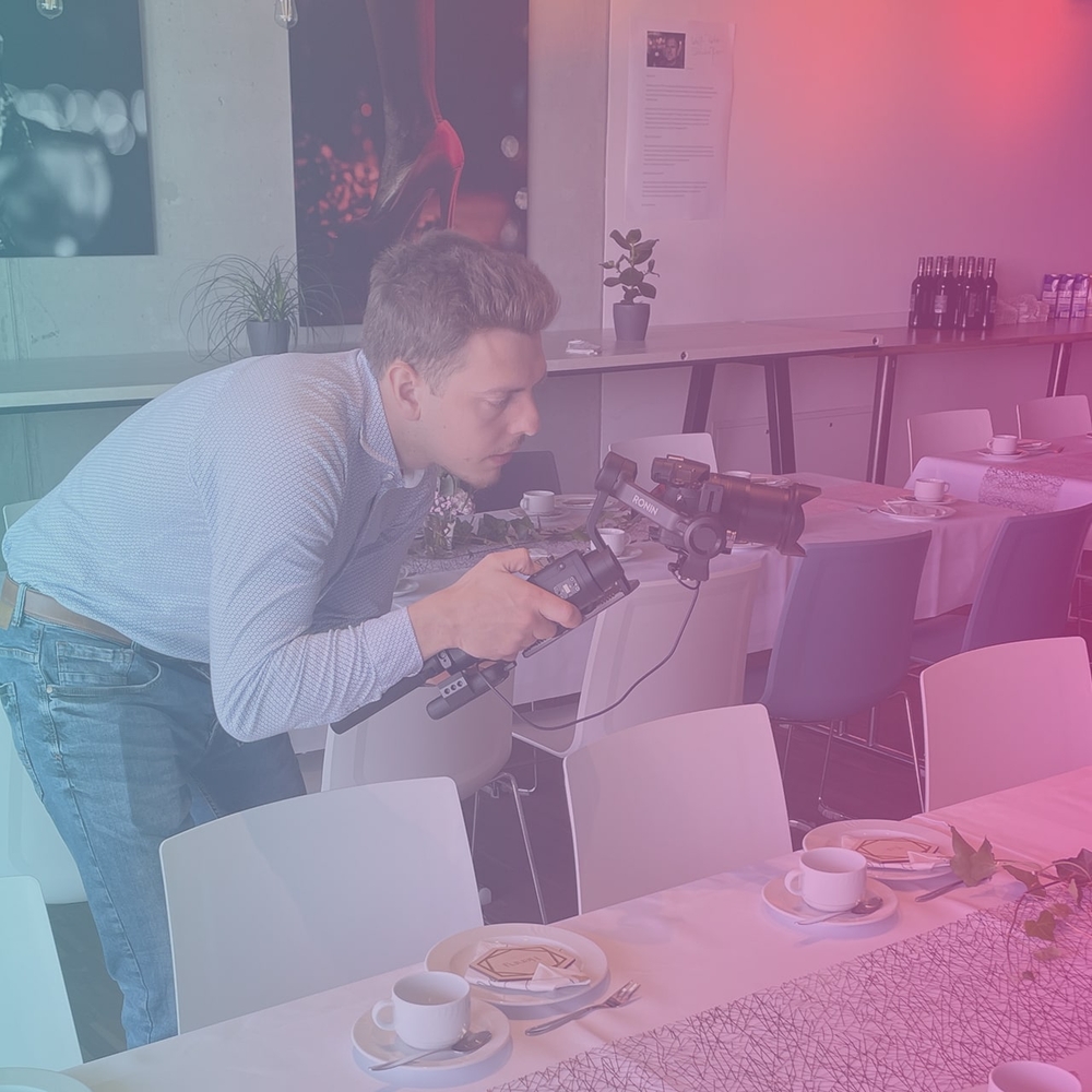 Filmemacher mit Kamera bei Dreharbeiten eines Eventfilms in einer Eventlocation