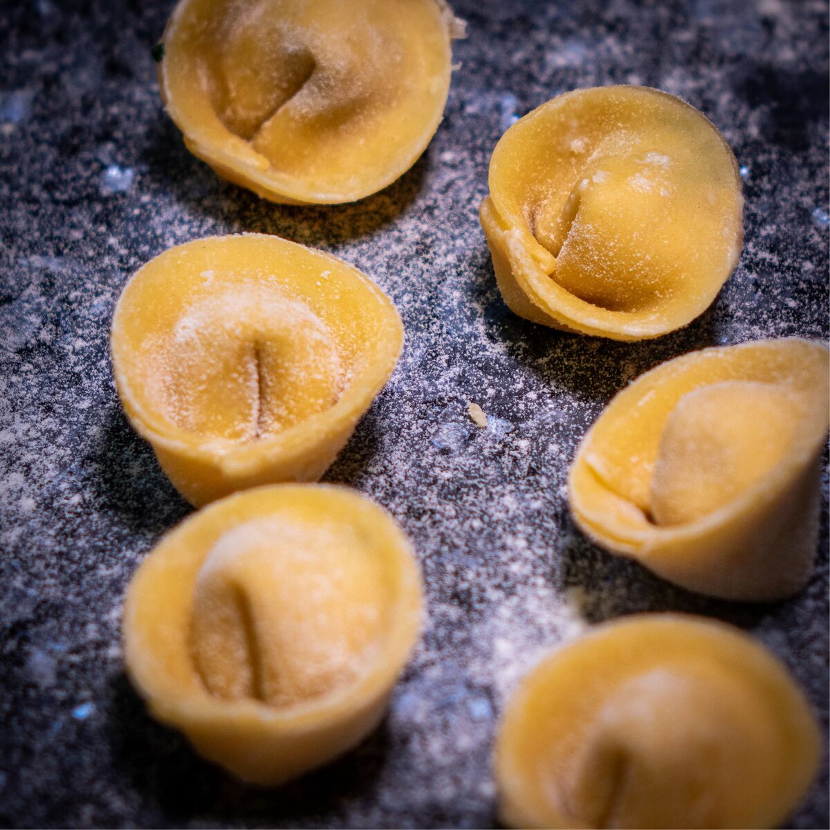 Mehrere ungekochte Tortellini auf einer bemehlten Arbeitsfläche in der Restaurantküche