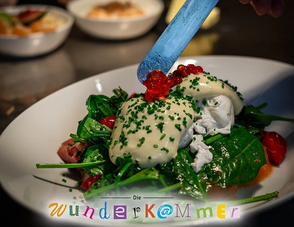 Anrichteszene eines Salatgerichts mit pochiertem Ei, Spinat und Kaviar im Café Die Wunderkammer Stuttgart
