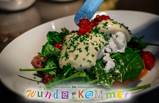 Anrichteszene eines Salatgerichts mit pochiertem Ei, Spinat und Kaviar im Café Die Wunderkammer Stuttgart